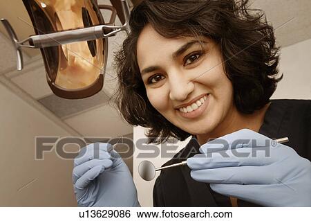 Stock Photograph - Female dentist at work. Fotosearch