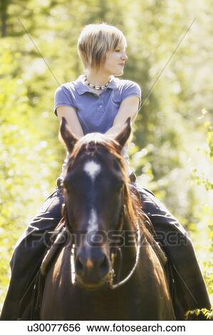 Stock Photograph - Girl riding a horse. Fotosearch