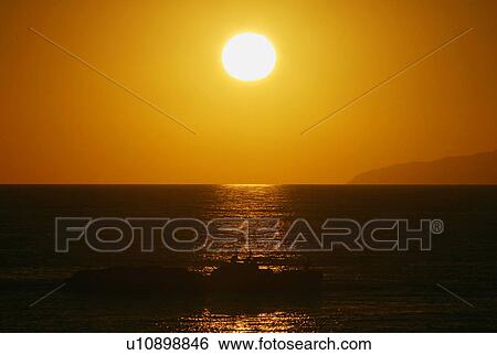 Stock Photograph - Golden sunset over a calm sea. Fotosearch