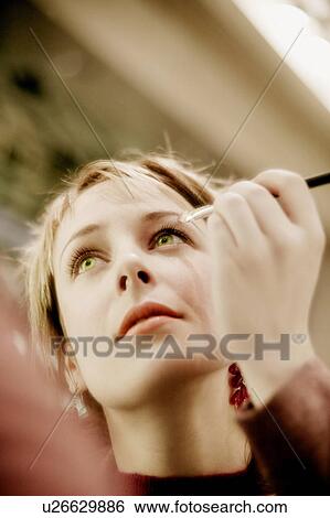 Lady applying eye shadow View Large Photo Image Stock Photograph - Lady applying eye shadow. Fotosearch
