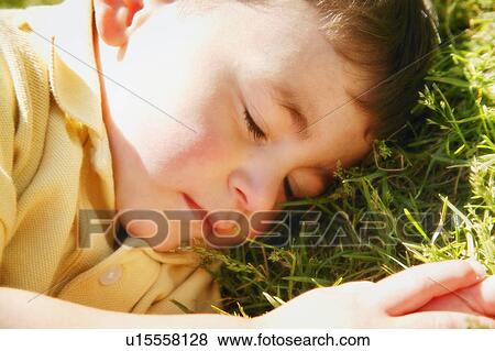 Stock Photo - Little boy asleep on the grass. Fotosearch