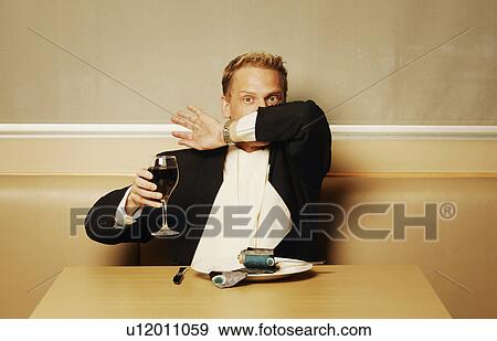 Stock Photo - Man delving into his tie for dinner. Fotosearch