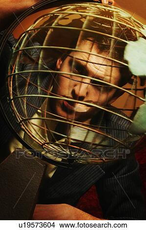 Man looking through metal globe View Large Photo Image Picture - Man looking through metal globe. Fotosearch