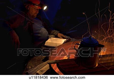 Man reading Bible at night next to fire View Large Photo Image Stock Photograph - Man reading Bible at night next to fire. Fotosearch