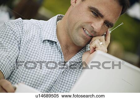 Stock Photography - Man talks on cell phone. Fotosearch