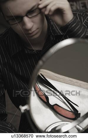 Stock Image - Man trying on glasses. Fotosearch