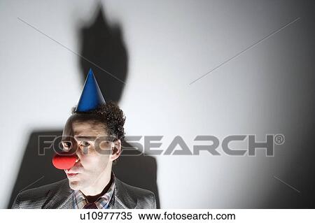 Stock Photography - Man wearing clown's nose and hat. Fotosearch