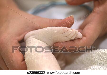 Stock Image - Newborn foot with mom. Fotosearch