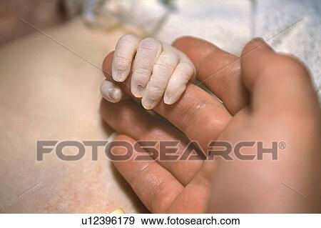 Stock Photo - Newborn hand with mom. Fotosearch