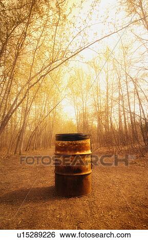 Stock Photograph - Old oil drum in the countryside being used as a garbage can. Fotosearch