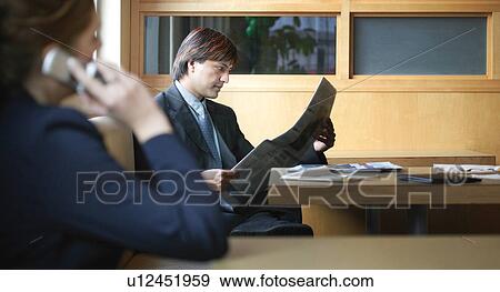Stock Photo - Professional man and woman in office environment. Fotosearch