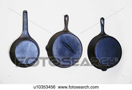 Stock Photograph - Set of 3 skillets on wall. Fotosearch