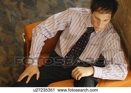 Stock Image - Smartly dressed man lounging in chair. Fotosearch