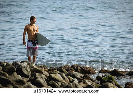 Surfer looking out to sea View Large Photo Image Picture - Surfer looking out to sea. Fotosearch