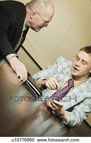 Two businessmen having a discussion View Large Photo Image Stock Image - Two businessmen having a discussion. Fotosearch