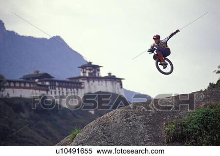 Unicyclist taking jump off hill View Large Photo Image Stock Photography - Unicyclist taking jump off hill. Fotosearch