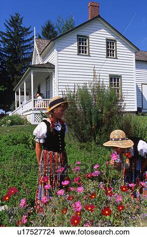 Picture - White house with garden and two girls in national dress. Fotosearch
