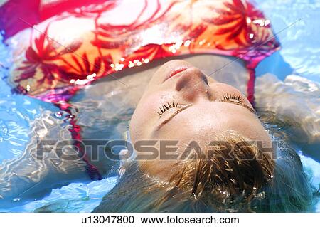 Stock Image - Woman floating in water. Fotosearch