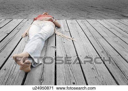 Woman lying on dock View Large Photo Image Stock Image - Woman lying on dock. Fotosearch