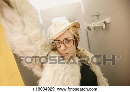 Stock Photo - Woman tries on a fur coat. Fotosearch