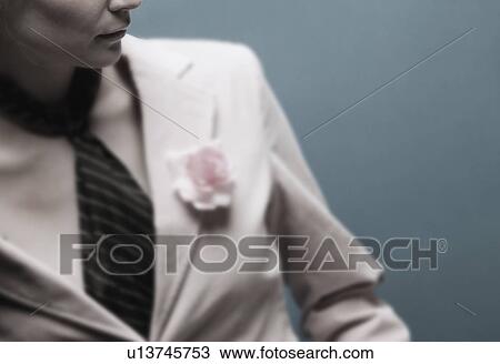 Stock Image - Woman wearing a suit with a pink flower. Fotosearch