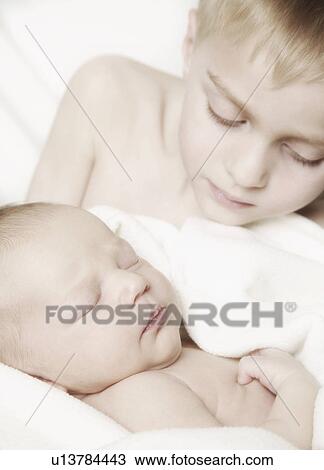 Young boy holding baby View Large Photo Image Stock Image - Young boy holding baby. Fotosearch