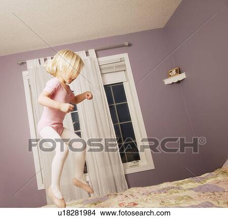 Picture - Young girl jumping on bed. Fotosearch