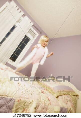 Young girl jumping on bed View Large Photo Image Stock Image - Young girl jumping on bed. Fotosearch