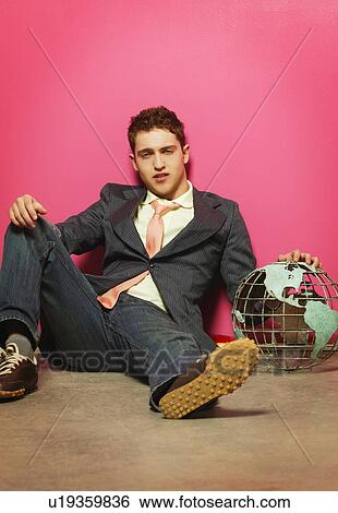 young man with globe sprawled against a wall View Large Photo Image Stock Photograph - young man with globe sprawled against a wall. Fotosearch