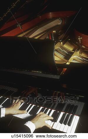 A pianist plays a grand piano View Large Photo Image Stock Photograph - A pianist plays a grand piano. Fotosearch