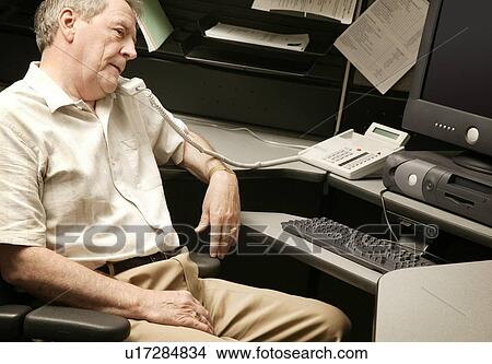 A senior businessman on the phone at his desk View Large Photo Image Picture - A senior businessman on the phone at his desk. Fotosearch