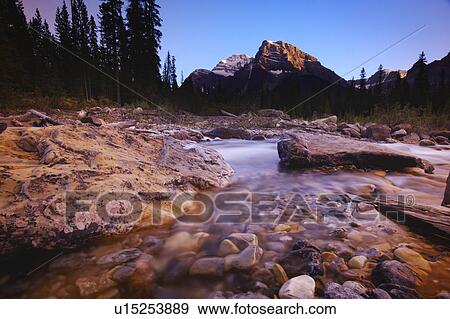 A stream with mountains in the background View Large Photo Image Stock Photo - A stream with mountains in the background. Fotosearch