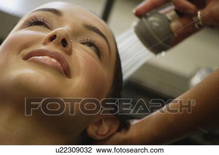 Stock Image - A woman getting her hair rinsed at a salon. Fotosearch