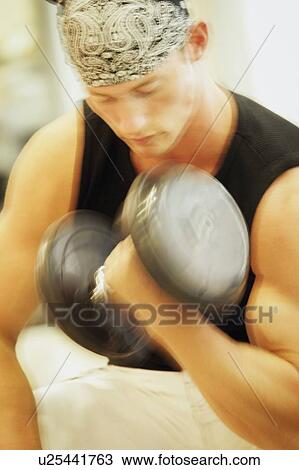 A young man doing a bicep curl View Large Photo Image Stock Image - A young man doing a bicep curl. Fotosearch