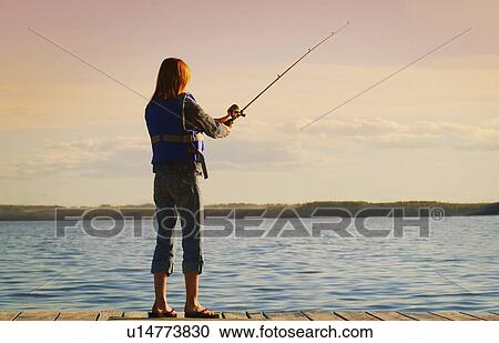 Stock Image - A young woman fishing off a dock. Fotosearch