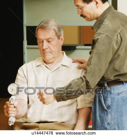 Stock Photo - An occupational therapist working with a senior businessman. Fotosearch