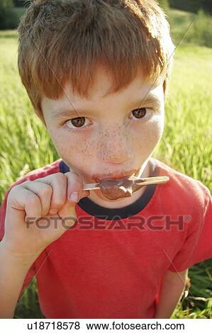 Stock Photo - Boy eating ice lolly. Fotosearch