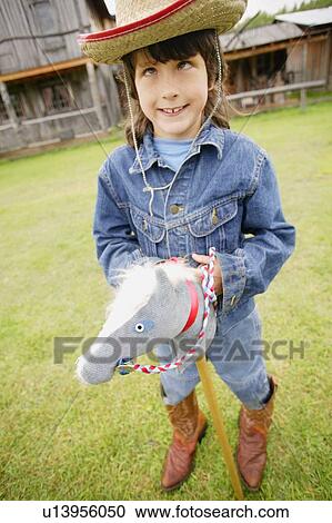 Child pretends to ride a horse View Large Photo Image Stock Image - Child pretends to ride a horse. Fotosearch