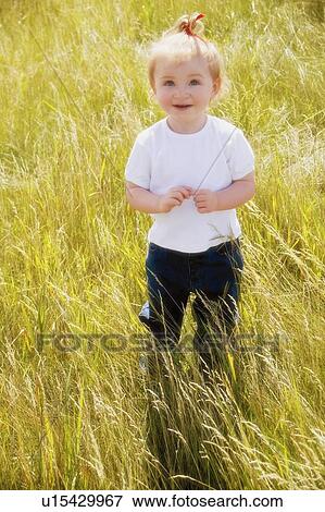 Child stands in a wheat field View Large Photo Image Stock Photo - Child stands in a wheat field. Fotosearch