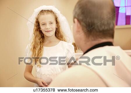 Child takes her first communion View Large Photo Image Stock Photo - Child takes her first communion. Fotosearch