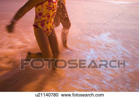 Stock Image - Children running through water. Fotosearch