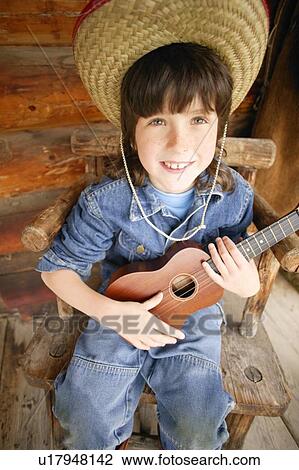 Stock Image - Cowboy strums a guitar. Fotosearch