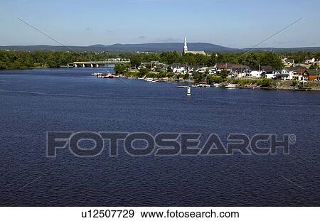 Stock Photo - Distant view of town across a river and surrounding country. Fotosearch