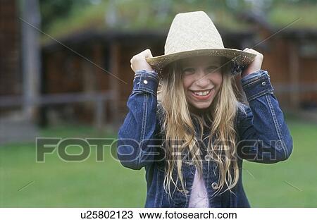 Girl puts hat on View Large Photo Image Stock Image - Girl puts hat on. Fotosearch