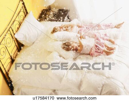 Stock Image - Girls resting after pillow fight. Fotosearch