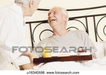 Stock Photo - Man has breakfast in bed. Fotosearch