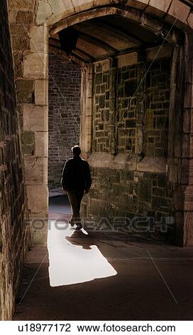 Man walking through arch View Large Photo Image Stock Image - Man walking through arch. Fotosearch