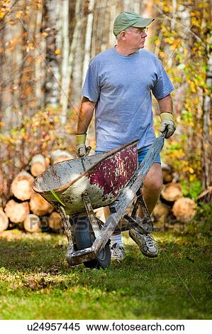 Man with wheelbarrow View Large Photo Image Stock Photography - Man with wheelbarrow. Fotosearch