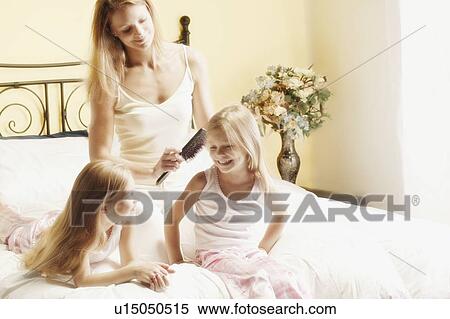 Mother brushing daughter's hair View Large Photo Image Stock Photography - Mother brushing daughter's hair. Fotosearch