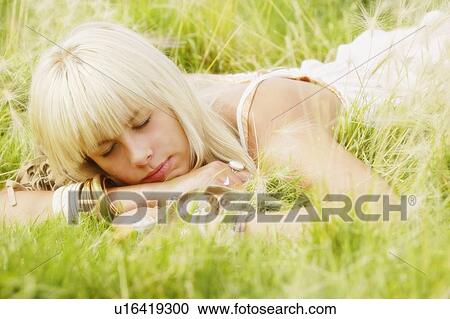 Portrait of woman lying in grass View Large Photo Image Stock Image - Portrait of woman lying in grass. Fotosearch